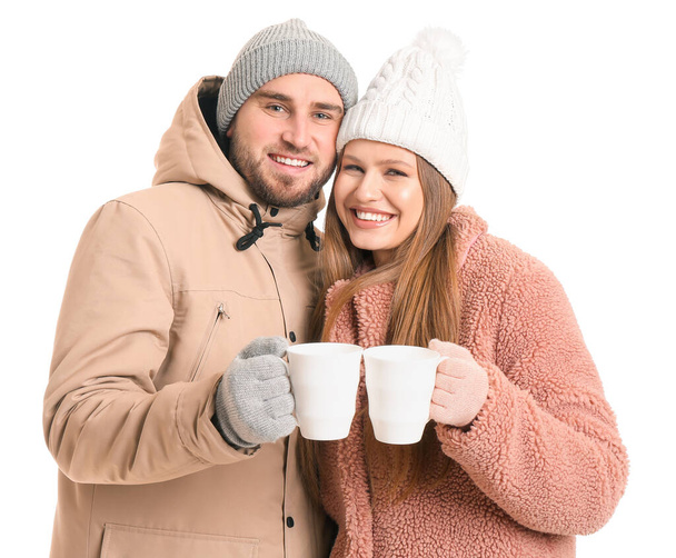 Portret szczęśliwej pary w zimowych ubraniach i filiżankach herbaty na białym tle - Zdjęcie, obraz