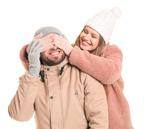 Happy woman covering eyes of her boyfriend against white background - Photo, Image
