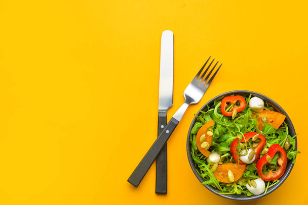 Тарілка зі смачним салатом на кольоровому фоні
 - Фото, зображення
