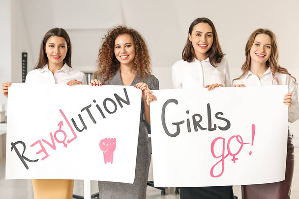 Молоді жінки з плакатами в офісі. Концепція фемінізму
 - Фото, зображення