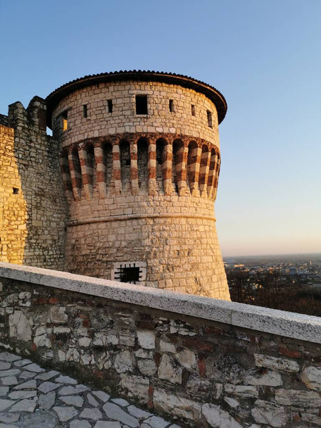 Murallas del castillo de Brescia y torre fortificada al atardecer
 - Foto, imagen
