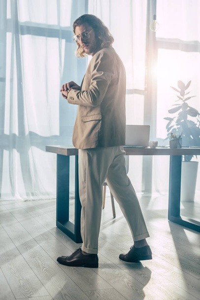 елегантний модний бізнесмен позує на сонячному світлі в офісі
 - Фото, зображення