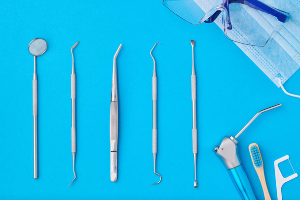Herramientas dentistas sobre fondo azul vista superior
 - Foto, imagen