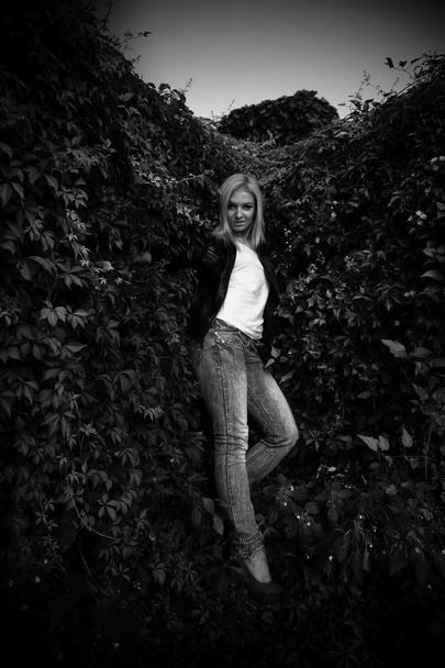 Woman posing near wall covered with plants - Fotografie, Obrázek