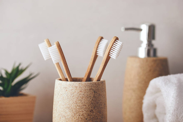 Close up of four bamboo toothbrushes in a cup - Zdjęcie, obraz