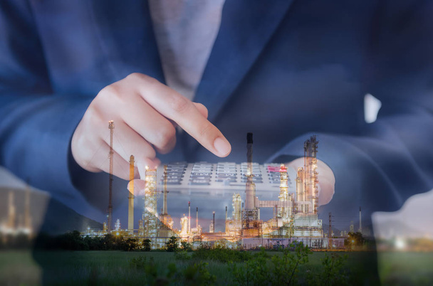 Business Accountant Woman Using Calculator for Calculating Financial Investment Profit Estimate, Double Exposure of Businesswoman is Calculating Tax Expense Against Oil/Gas Refinery Plant Background. - Fotoğraf, Görsel