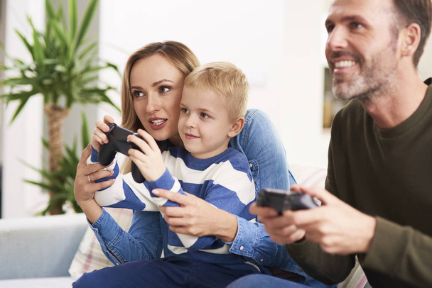 Emotionele ouders en zoon spelen video game - Foto, afbeelding
