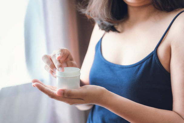 美容ボディスキンケアと化粧品適用の概念は、女性の手のクローズアップは、健康な肌のための保湿ローションクリームを適用しています。美しい女性は彼女の手の上に保湿エイジング治療を使用しています. - 写真・画像