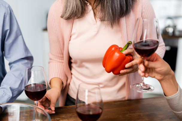 cropped view of women holding bell pepper and wine glass  - Fotografie, Obrázek