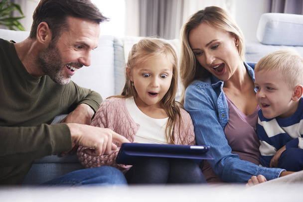 Překvapení rodiče s dětmi při pohledu na tablet   - Fotografie, Obrázek