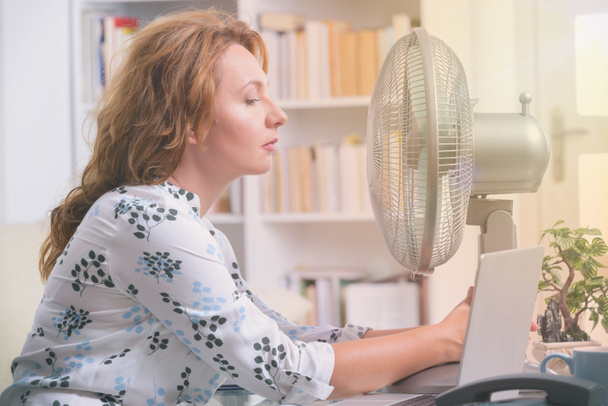 Жінка страждає від спеки в офісі або вдома
 - Фото, зображення