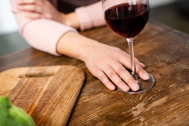 обрезанный вид женщины, держащей бокал вина на кухне
  - Фото, изображение