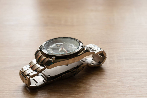 men's watch lying on a table in the sunlight - Photo, Image