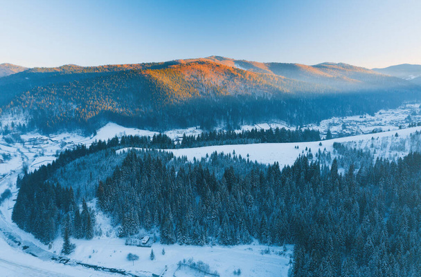 Drohnenbild des Winterflusses und des Waldes in den Bergen bei Sonnenuntergang - Foto, Bild