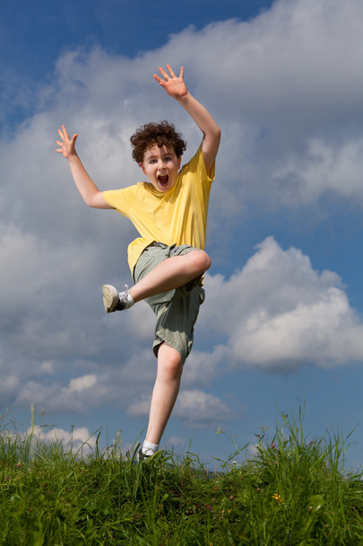 Boy jumping against blue sky - Photo, image