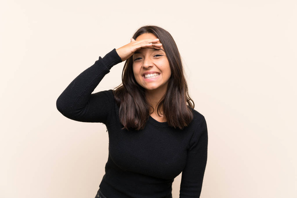 Jeune femme brune avec pull blanc sur fond isolé regardant loin avec la main pour regarder quelque chose
 - Photo, image