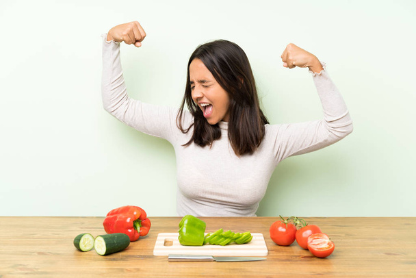 Young brunette woman with vegetables celebrating a victory - Photo, Image