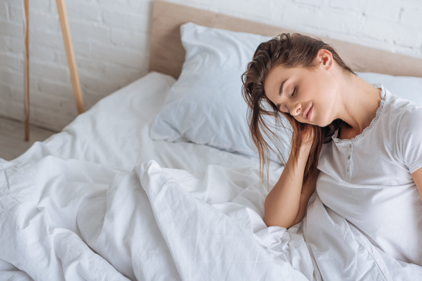 mujer soñadora con los ojos cerrados descansando en la cama
  - Foto, Imagen