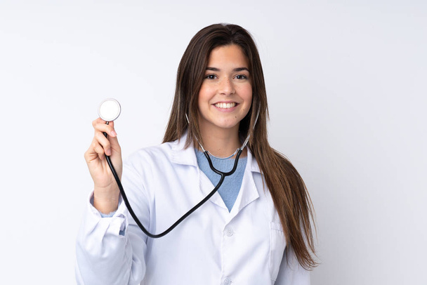 Дівчина-підліток над ізольованим білим тлом в одязі лікаря і зі стетоскопом
 - Фото, зображення