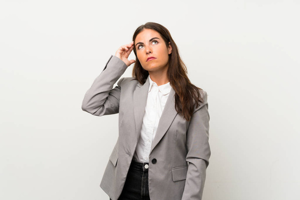 Young business woman over isolated white background having doubts and with confuse face expression - Fotoğraf, Görsel