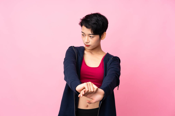 Mladý sport asijské žena přes izolované růžové pozadí strečink rameno - Fotografie, Obrázek
