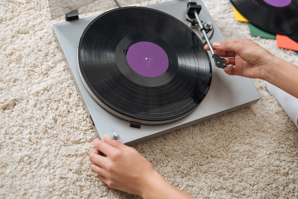 cropped view of young woman touching retro record player  - Foto, Bild