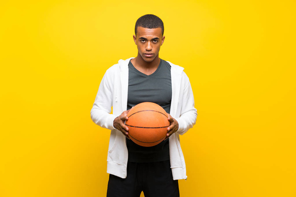 Afro American basketball player man over isolated yellow background - Photo, Image