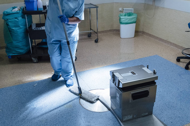 Concept foto van een ziekenhuis werknemer doet schoonmaken in bedrijf r - Foto, afbeelding