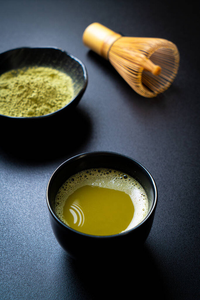 hot matcha green tea cup with green tea powder and whisk - Foto, imagen