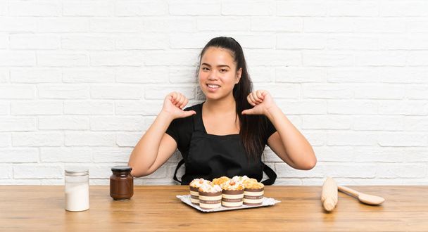 młody nastolatek Azji dziewczyna z wiele muffin ciasto dumny i zadowolony z siebie - Zdjęcie, obraz