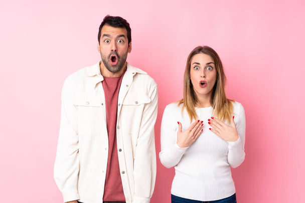 Couple in Valentine Day over isolated pink background with surprise and shocked facial expression - Valokuva, kuva