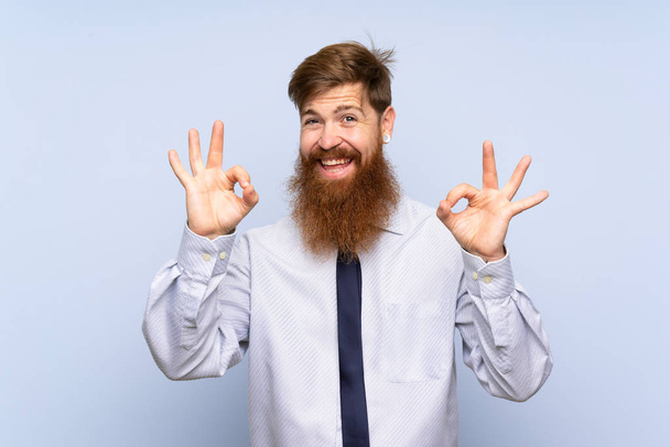 Бизнесмен с длинной бородой на изолированном фоне показывает знак ОК с пальцами
 - Фото, изображение