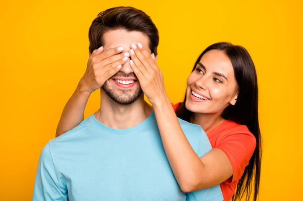Guess who. Photo of two adorable guy lady people couple closing eyes romance surprise visit wear casual blue orange t-shirts isolated yellow color background - Photo, image