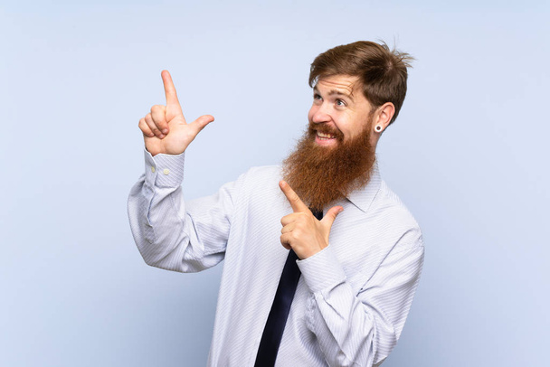 Uomo d'affari con lunga barba su sfondo isolato che punta con l'indice una grande idea
 - Foto, immagini