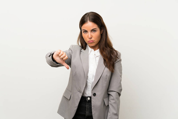 Jonge zakenvrouw over geïsoleerde witte achtergrond tonen duim naar beneden teken - Foto, afbeelding