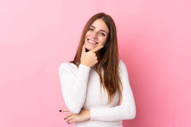 Молода жінка над ізольованим рожевим тлом посміхається
 - Фото, зображення