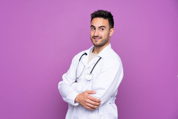 Young man wearing a doctor gown and with arms crossed - Photo, Image