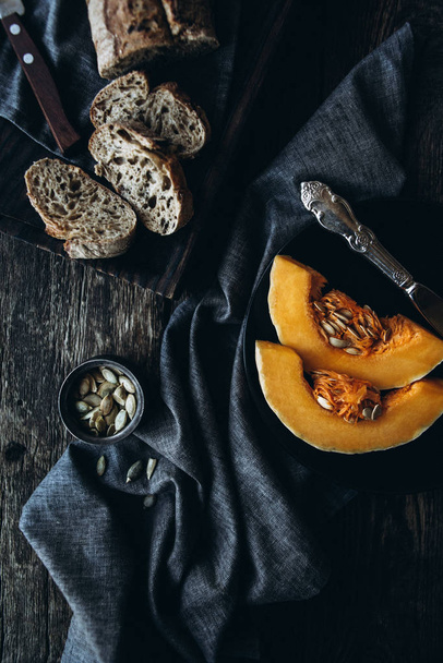 Тыквенные ломтики в композиции с темным хлебом и семенами тыквы
 - Фото, изображение