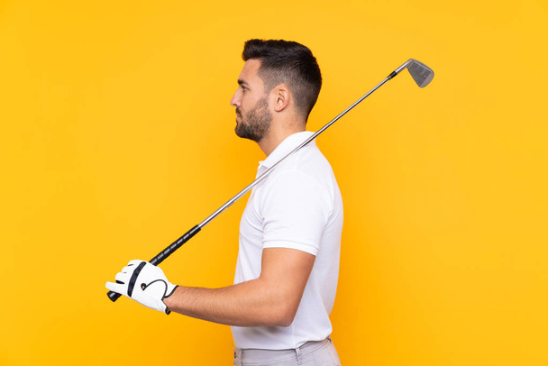 Hombre sobre aislado fondo amarillo jugando golf
 - Foto, imagen