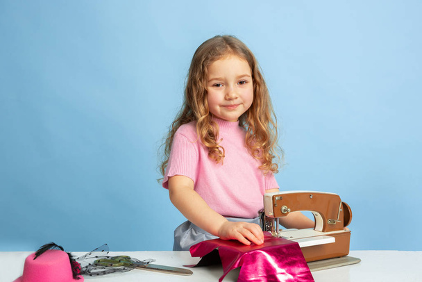 Little girl dreaming about future profession of seamstress - Valokuva, kuva