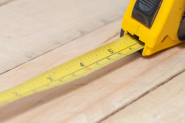 tape measure on the brown wooden background - 写真・画像