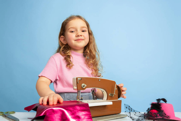 Little girl dreaming about future profession of seamstress - Foto, Bild