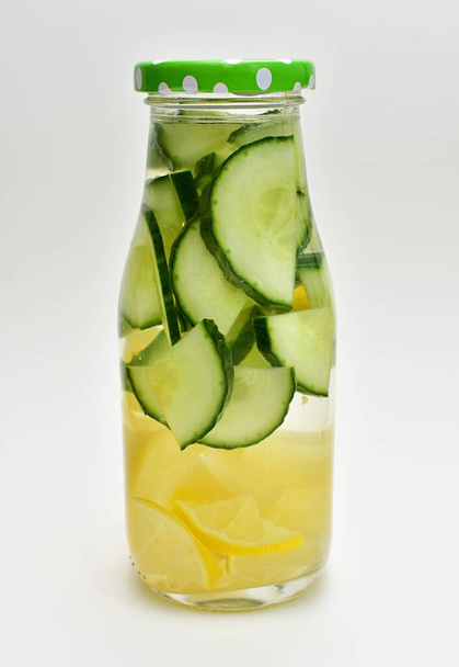 Água desintoxicada infundida em garrafa com pepino e fatias de limão
. - Foto, Imagem