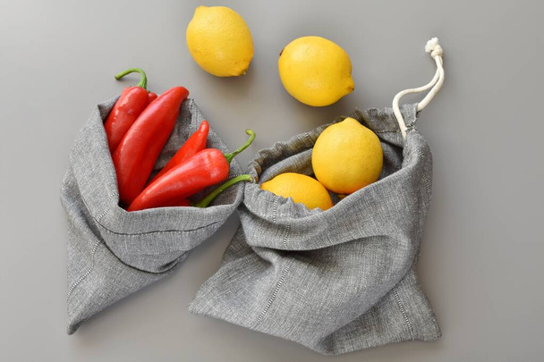Herbruikbare linnen produceren zakken met citroenen en rode peper, geen afval, geen plastic concept. - Foto, afbeelding