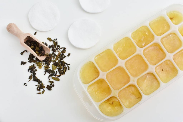 Cubos de hielo de té verde para el cuidado de la piel, remedio natural para los ojos hinchados
. - Foto, Imagen