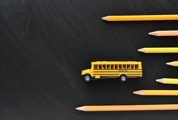 Back to school concept, education, yellow school bus and pencils on black chalkboard, copy space. - 写真・画像