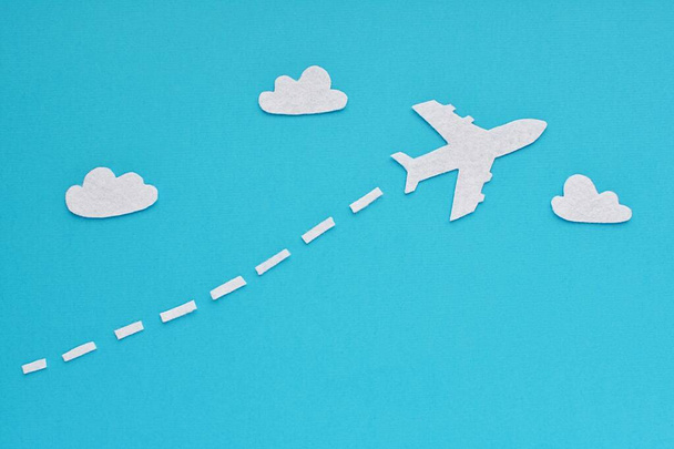Creative travel concept, felt fabric plane and clouds on blue background. - 写真・画像