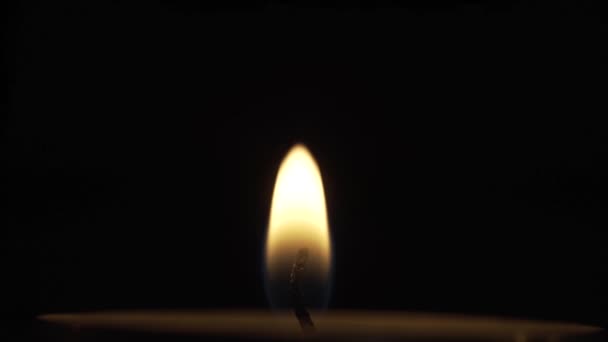 Een eenzame en stille kaarsvlam in complete duisternis - Video