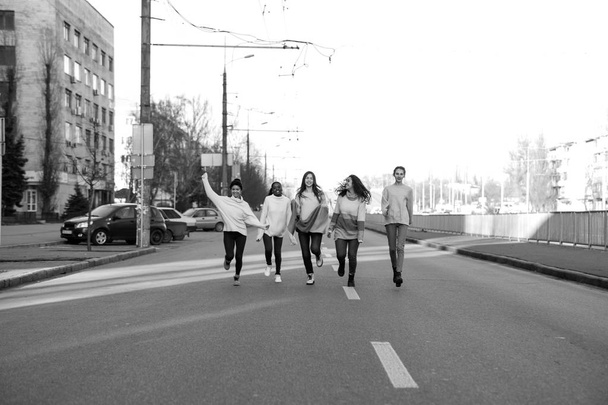 multirassische Gruppe von Freunden rennt und hat Spaß auf der Straße. - Foto, Bild