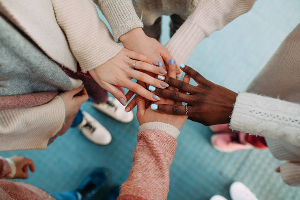 Dłonie kobiet różnych ras dotykają się nawzajem z bliska. - Zdjęcie, obraz